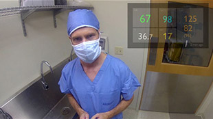 Un m&eacute;decin au bloc op&eacute;ratoire avec les param&egrave;tres vitaux affich&eacute;s dans le coin sup&eacute;rieur droit de son champ de vision.